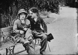 Mabel Normand and Charlie Chaplin on a park bench. 