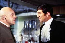 Telly Savalis and George Lazenby in On Her Majesty's Secret Service. Telly Savalis and George Lazenby in On Her Majesty's Secret Service.