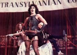 Frank-N-Furter sings while Magenta and Riff Raff look on.